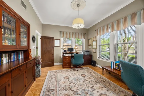 a living room with furniture large window and wooden floor