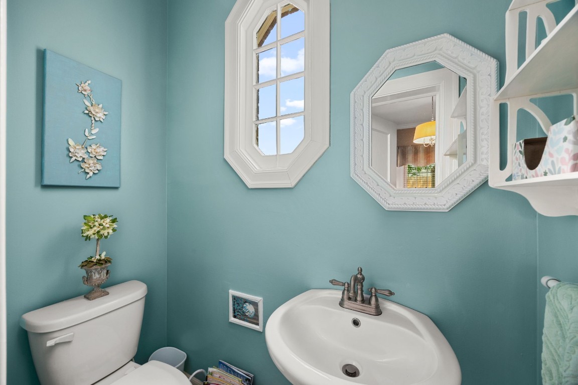 801 West Main Street Brenham, TX 77833 - Photo 8 of 50 Conveniently located just off the study, the half bathroom features charming historic touches including an octagonal window that fills the space with natural light. Soft colors and classic details create an inviting and functional addition to the office area.