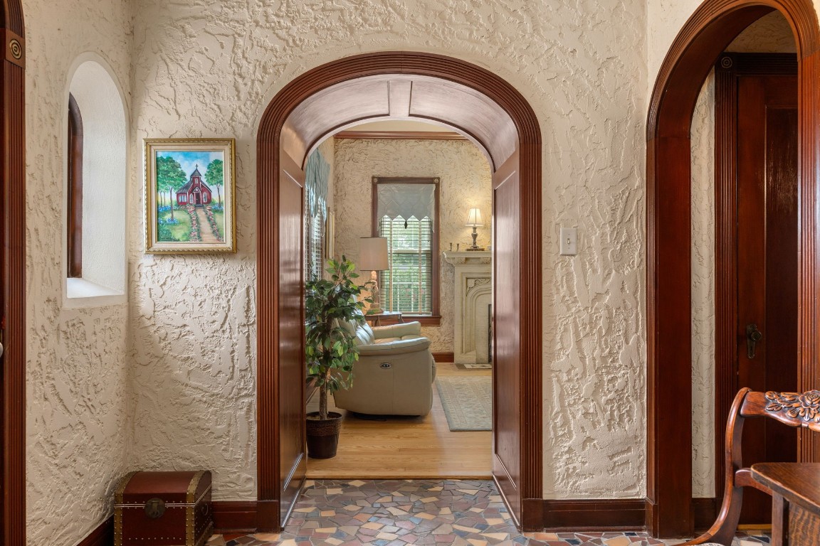 801 West Main Street Brenham, TX 77833 - Photo 9 of 50 Graceful arched openings framed with rich wood trim create a striking transition from the foyer to the formal living area. These beautifully preserved architectural details highlight the home's 1930s craftsmanship.