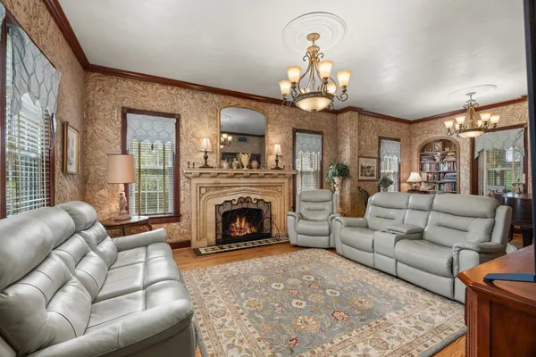 a living room with furniture a fireplace and a chandelier