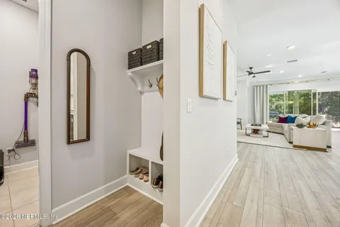 a living room with furniture kitchen view and a wooden floor