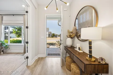 a view of a hallway with wooden floor and a living room