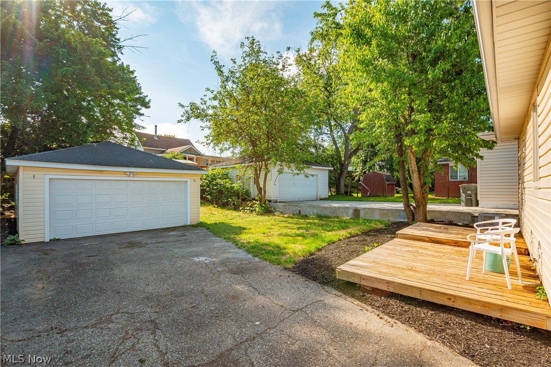 421 Hillman Road Akron, OH 44312 - Photo 24 of 27 View of yard with an outdoor structure, a garage, and a wooden deck