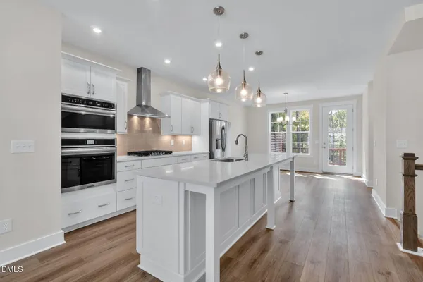 a kitchen with stainless steel appliances kitchen island granite countertop a stove a sink and a refrigerator