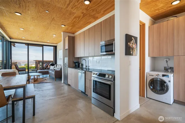 a kitchen with a stove a sink and a refrigerator with wooden floor