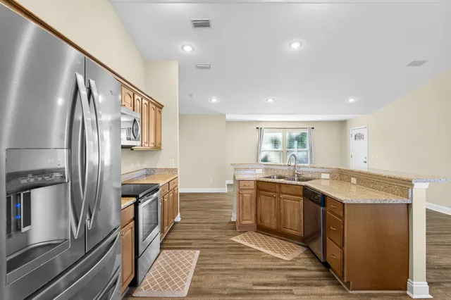 a kitchen with stainless steel appliances granite countertop a sink and stove top oven