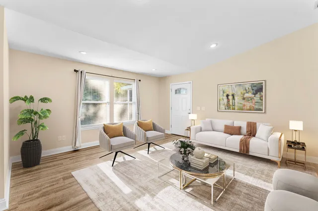 a living room with furniture potted plant and wooden floor