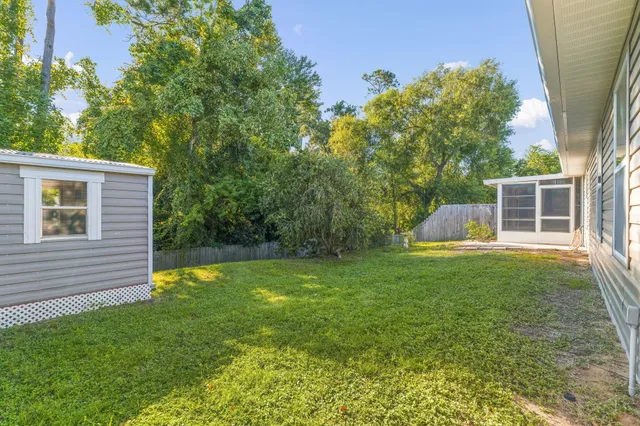 a view of a house with backyard and a garden