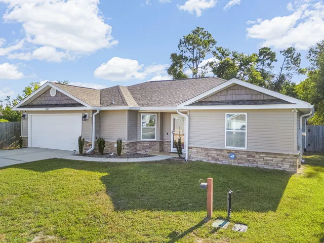 a front view of a house with a yard fire pit and outdoor seating