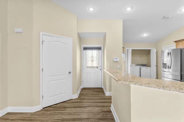 a view of a hallway with wooden floor and staircase
