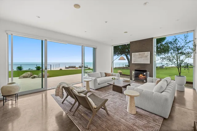 a living room with furniture and a dining table with garden view
