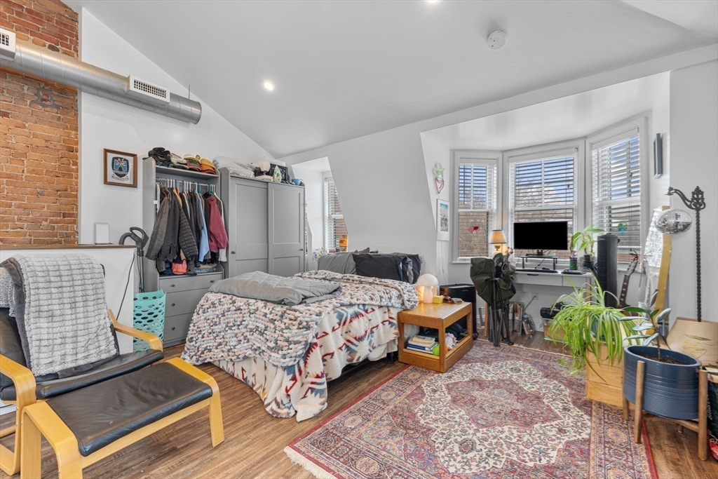 105 Broadway, Unit 3 Chelsea, MA 02150 - Photo 6 of 14 a bedroom with bed a flat tv screen and a dresser