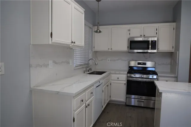 a kitchen with white cabinets and stainless steel appliances