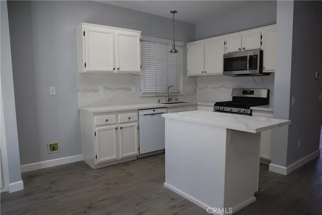 a kitchen with cabinets stainless steel appliances and a counter space