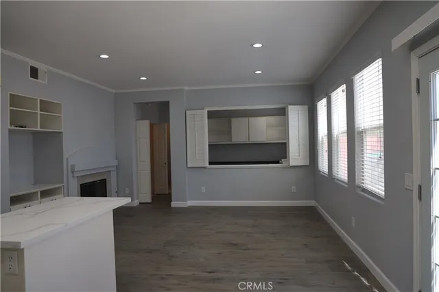 a view of hallway with window and wooden floor