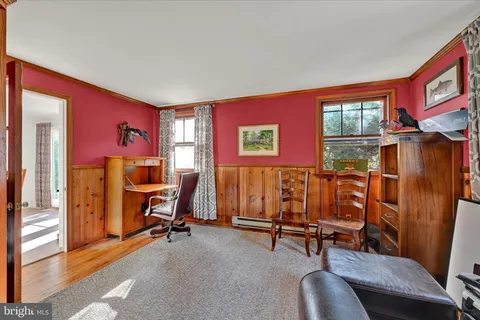 a view of a livingroom with workspace and a window