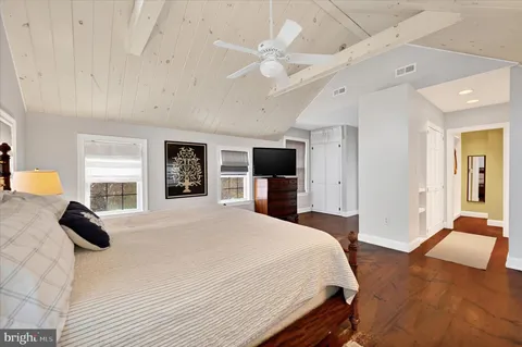 a bedroom with a bed a ceiling fan and a large window