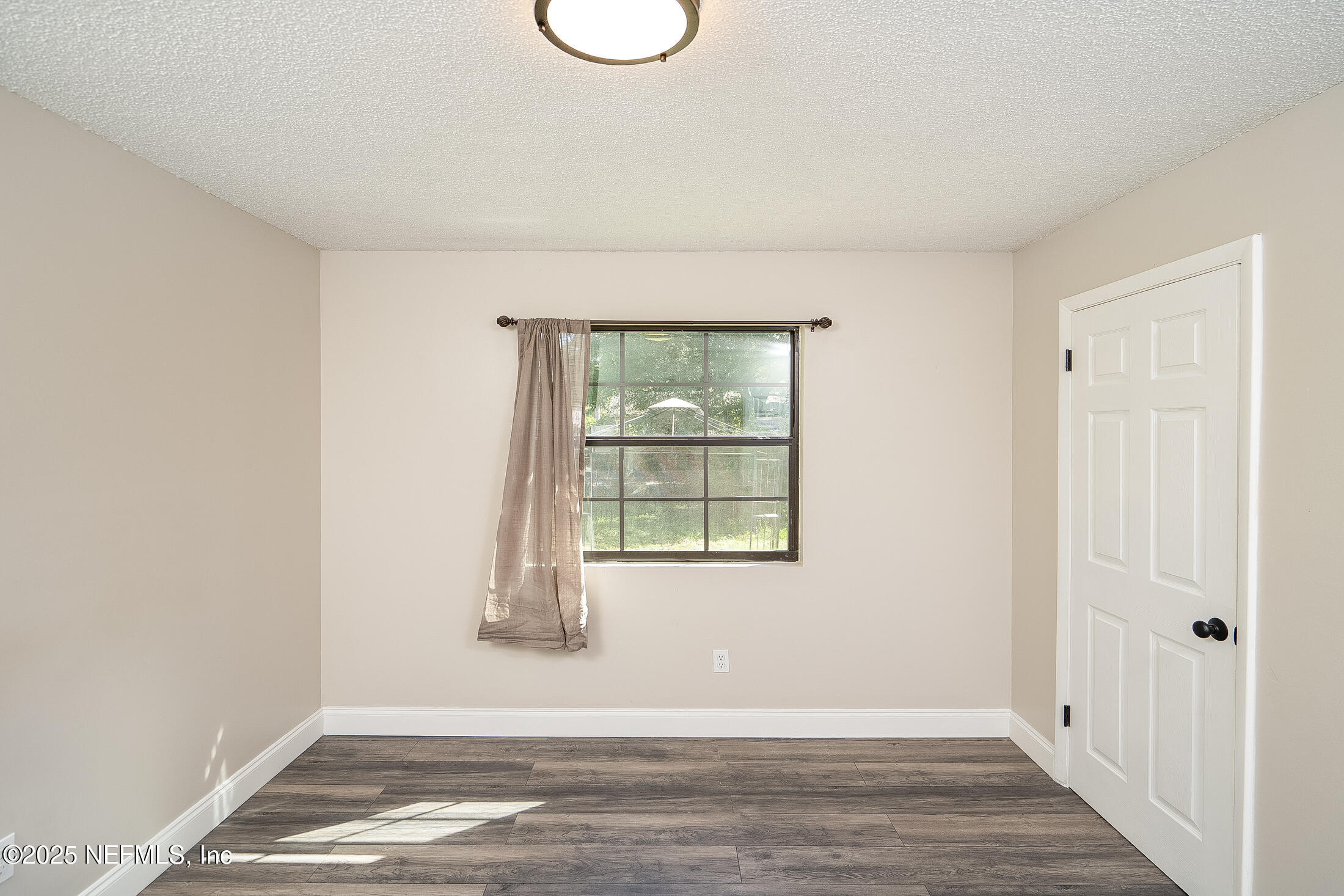 1131 Butler Avenue St. Augustine, FL 32084 - Photo 12 of 15 a view of an empty room with wooden floor and a window