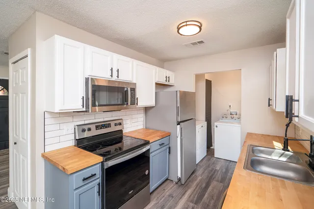 a kitchen with stainless steel appliances a stove microwave and a refrigerator