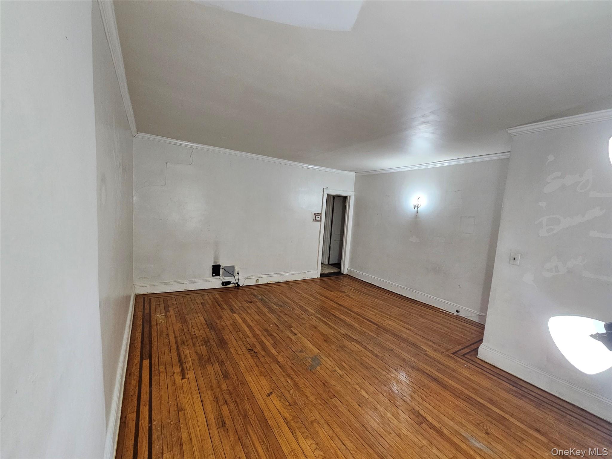 177-19 Troutville Road Queens, NY 11434 - Photo 2 of 5 Unfurnished room featuring wood-type flooring and crown molding