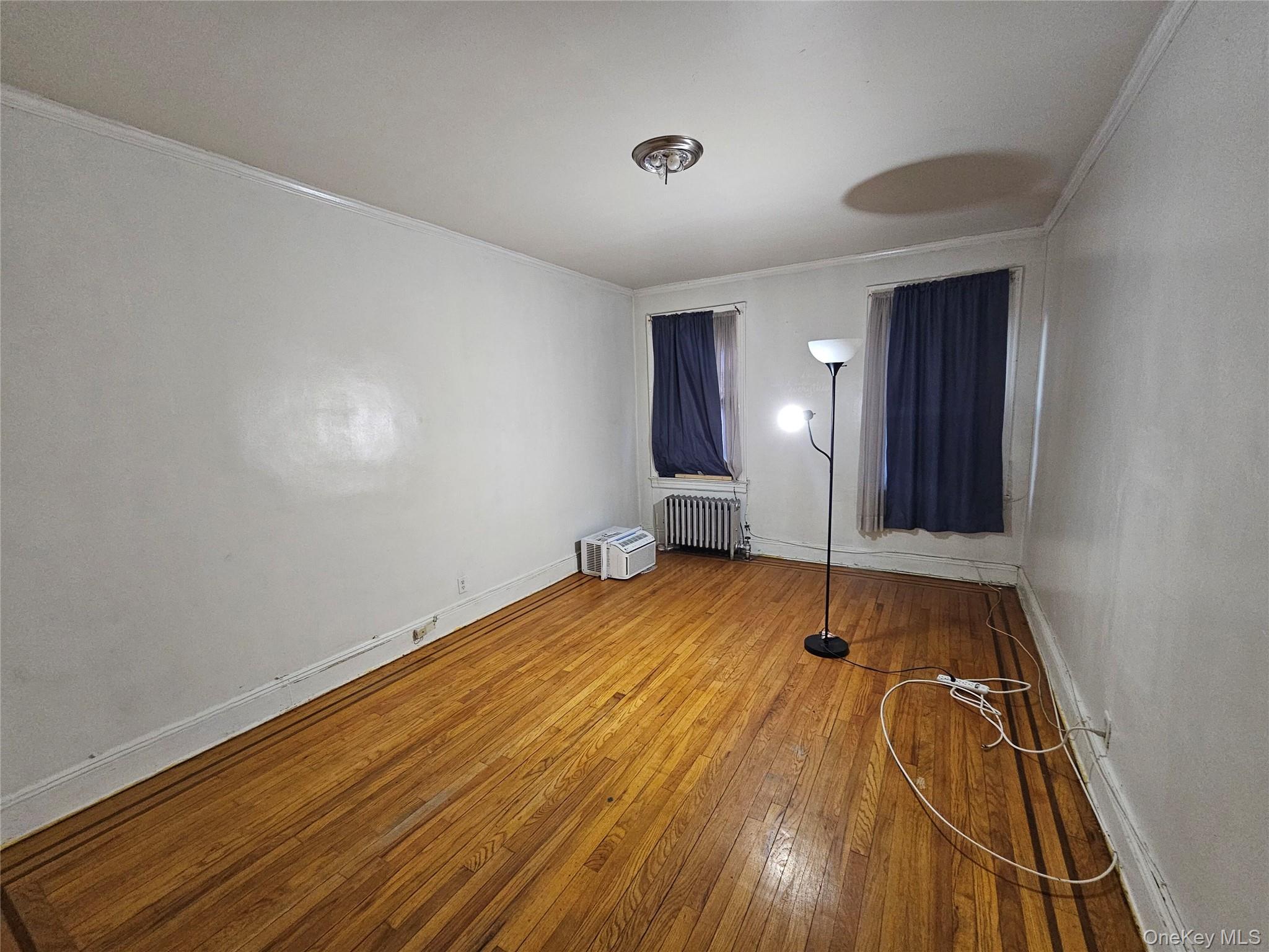 177-19 Troutville Road Queens, NY 11434 - Photo 5 of 5 Unfurnished bedroom featuring crown molding, radiator, and hardwood / wood-style floors