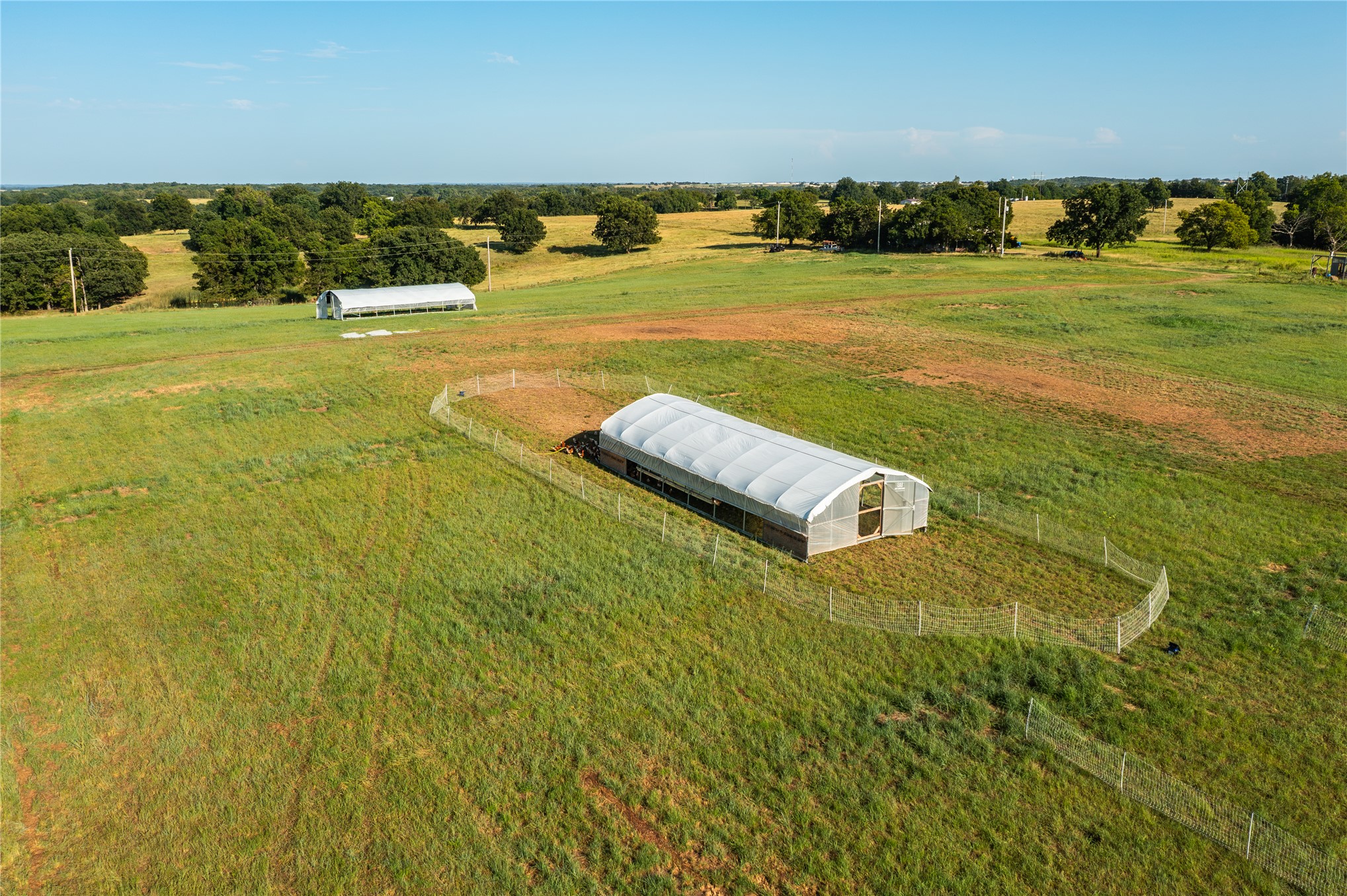 0 West Dunkin Road Cushing, OK 74023 - Photo 11 of 62 Expansive acreage featuring two hoop structures, fenced enclosure, and surrounding mature trees