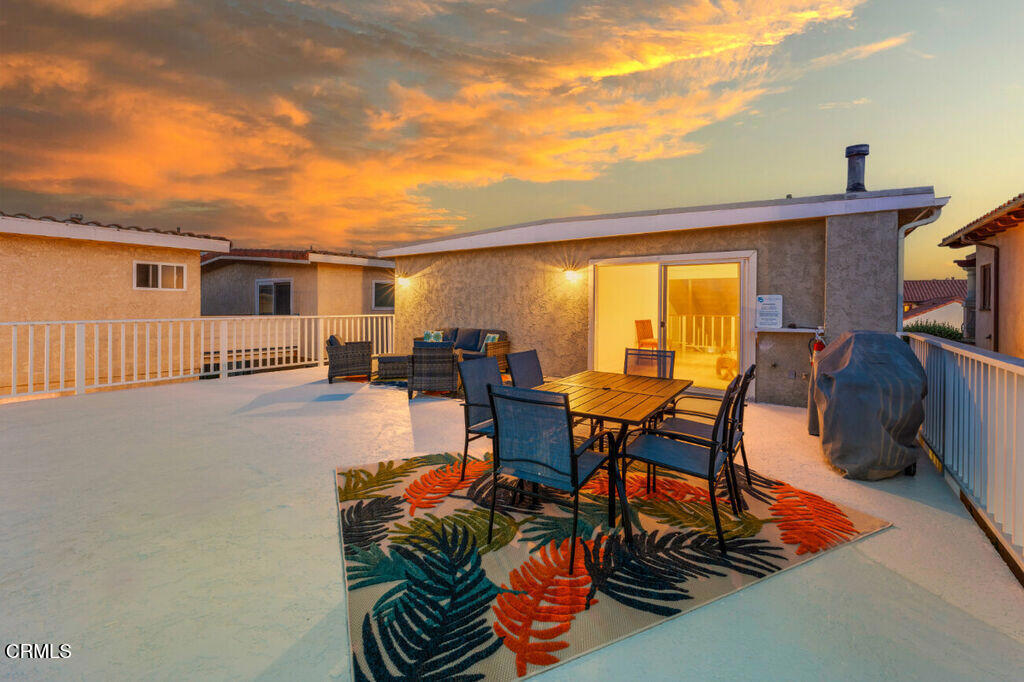 a view of a patio with table and chairs with wooden floor and fence