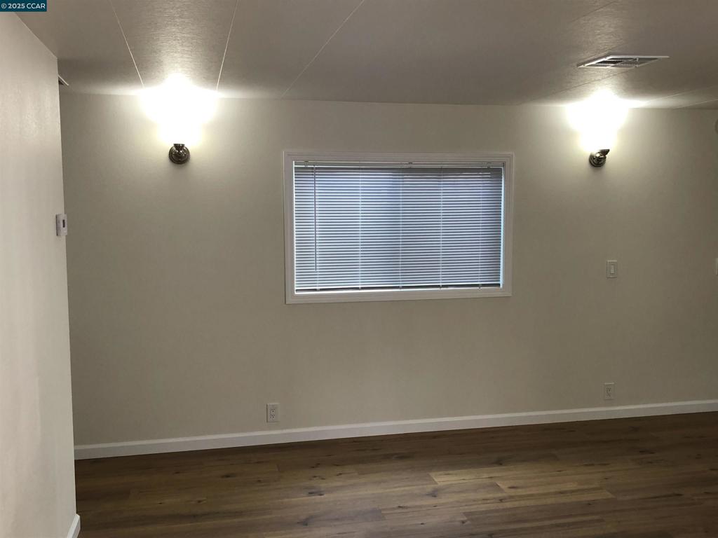 4556 Appian Way El Sobrante, CA 94803 - Photo 14 of 16 a view of an empty room with wooden floor and a window