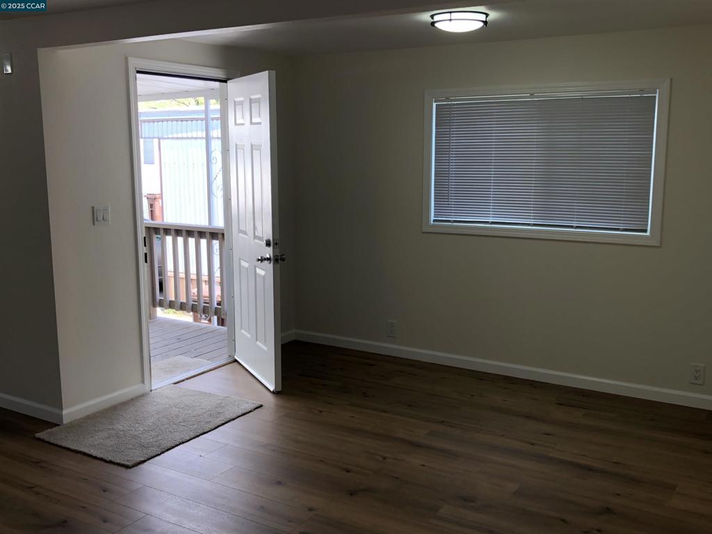 4556 Appian Way El Sobrante, CA 94803 - Photo 4 of 16 a view of an empty room with wooden floor and a window
