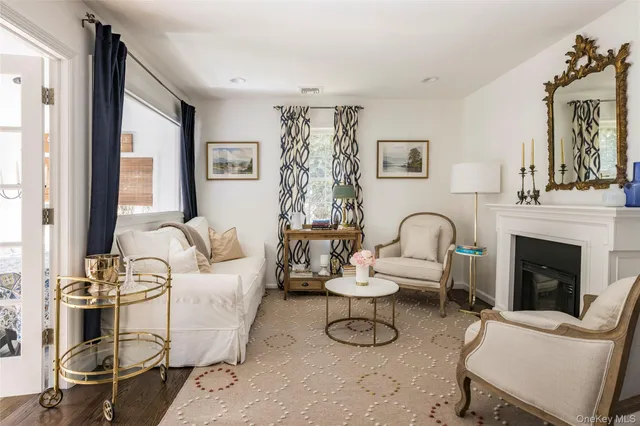 a living room with furniture a fireplace and large windows