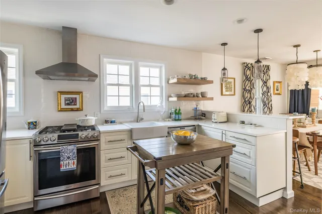 a kitchen with a stove a sink and a wooden floor
