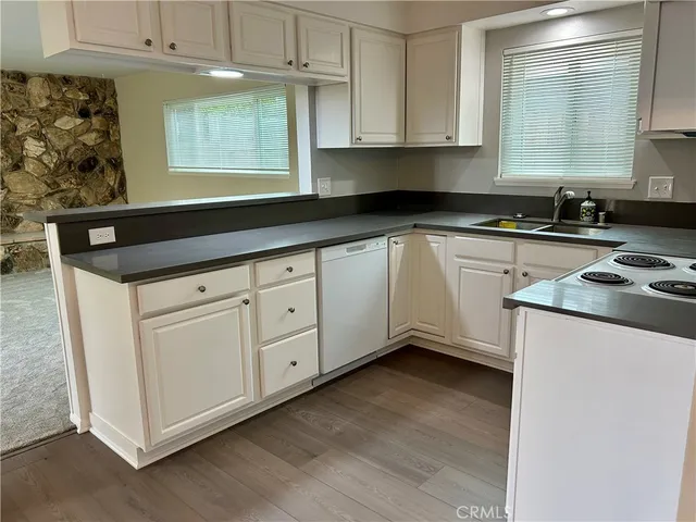 a kitchen with granite countertop white cabinets and white appliances