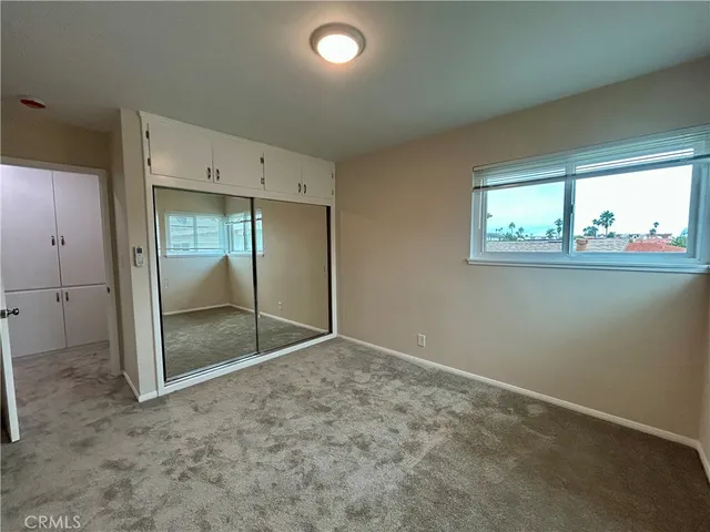 an empty room with windows and closet