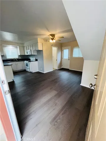 wooden floor in an empty room with a kitchen