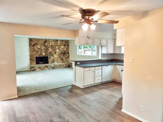 a kitchen with granite countertop a stove a sink and a microwave oven with white cabinets