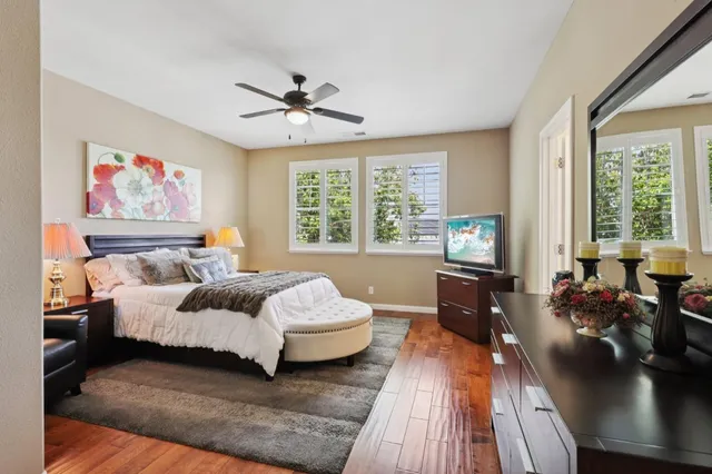 a spacious bedroom with a bed a couch and a large window