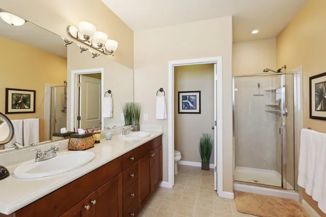 a bathroom with a double vanity sink mirror and shower
