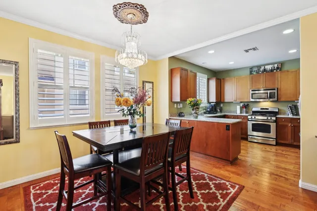 a dining room with furniture a chandelier and wooden floor
