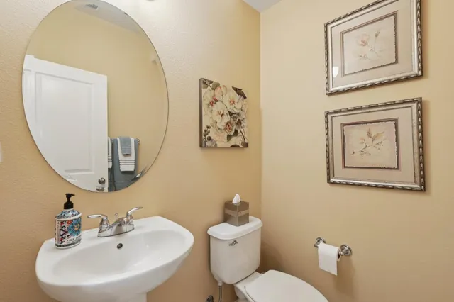 a bathroom with a toilet a sink and mirror
