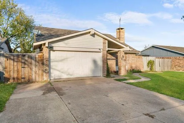 a view of a white house with a small yard and large trees