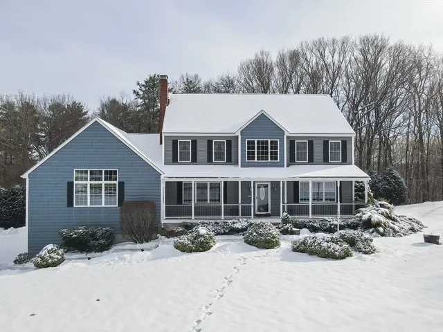 front view of a house with a yard covered in snow