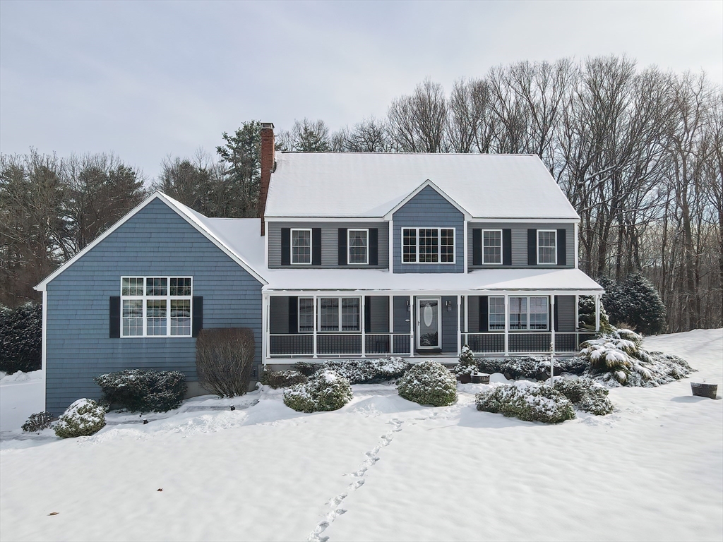 front view of a house with a yard covered in snow