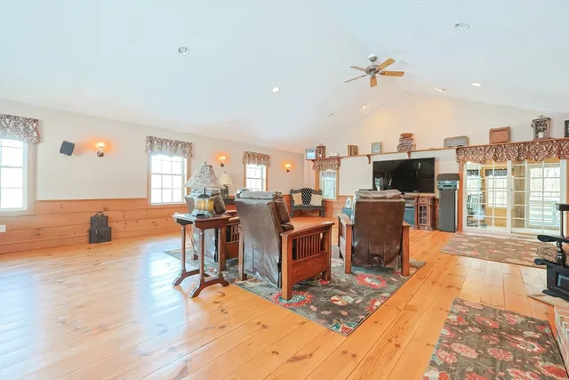 a living room with furniture a flat screen tv and floor to ceiling window