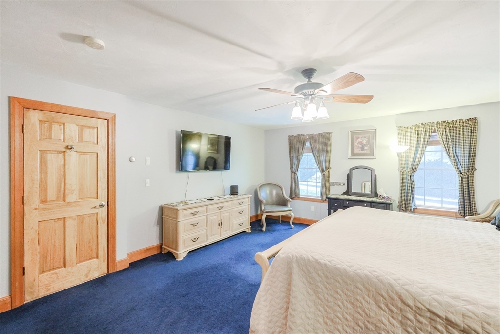 11 Brigham Road Paxton, MA 01612 - Photo 23 of 42 a spacious bedroom with a bed and a chandelier
