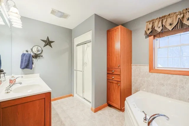 a bathroom with a tub sink and mirror
