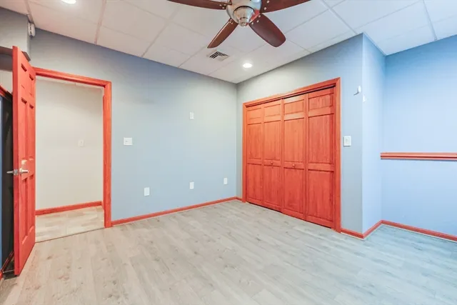 an empty room with closet and chandelier fan