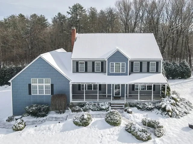 a front view of a house with a yard covered in snow