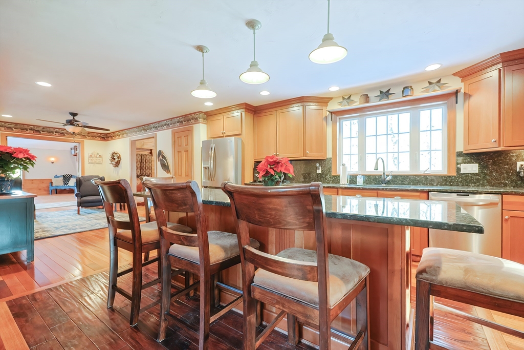 11 Brigham Road Paxton, MA 01612 - Photo 6 of 42 a kitchen with stainless steel appliances granite countertop a stove a sink a dining table and chairs with wooden floor