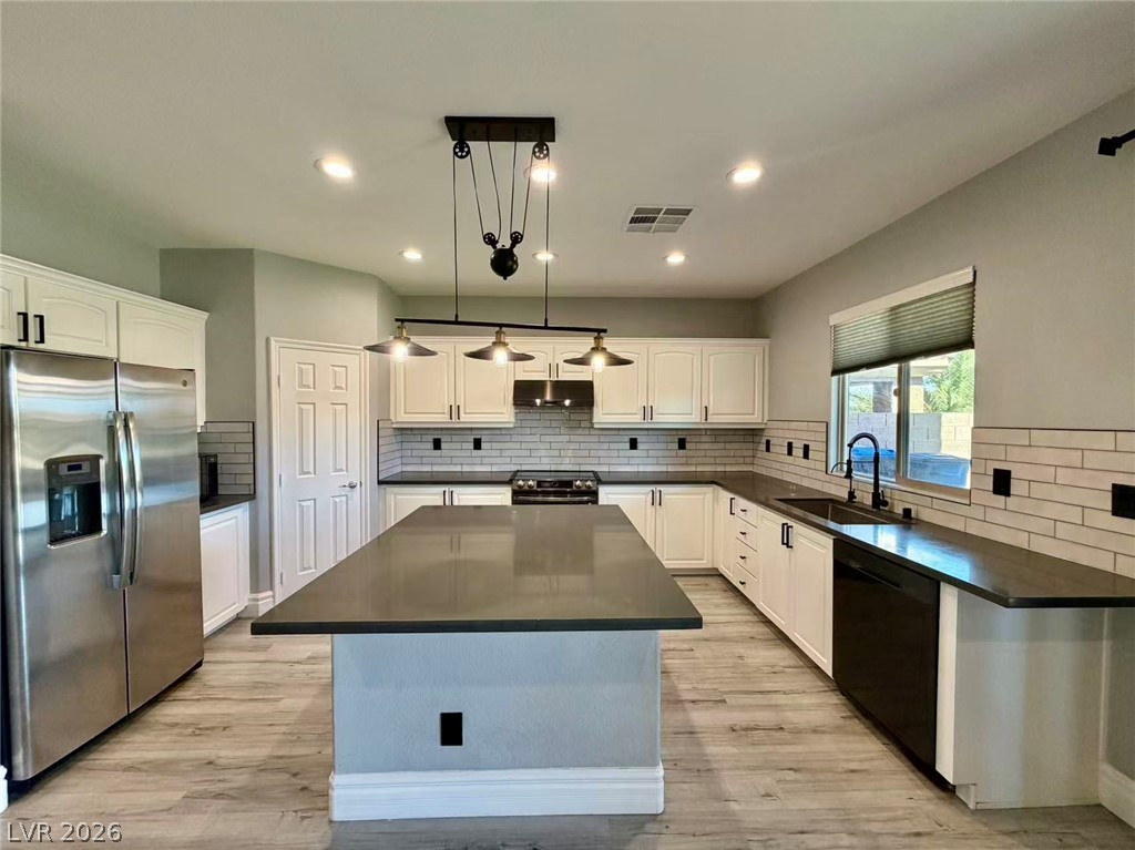 135 Tall Ruff Drive Las Vegas, NV 89148 - Photo 5 of 29 A contemporary kitchen showcases sleek cabinetry, subway tile backsplash, and a large central island.