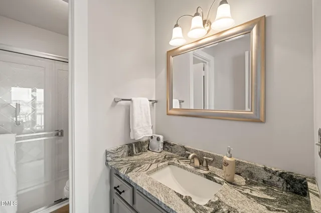 a bathroom with a granite countertop sink and a mirror